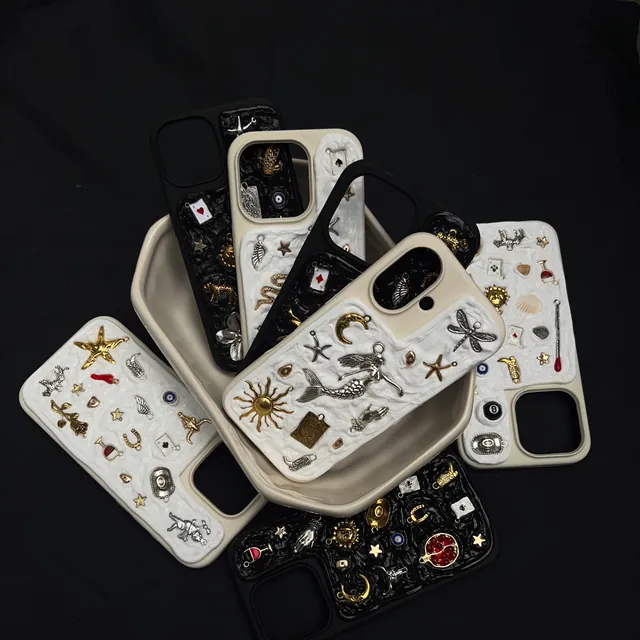 Varias fundas ASTÉRIA blancas y negras llenas de charms
